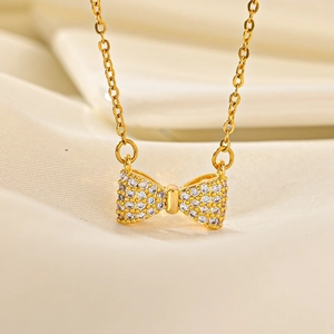 Macro shot of gold butterfly pendant with sparkling cubic zirconia on silk fabric