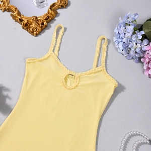 Close-up of yellow knit tank top featuring ruffle straps and a keyhole neckline detail