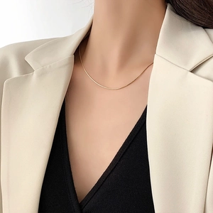 Minimalist 18K gold plated stainless steel snake bone chain necklace worn by a model