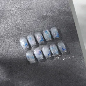 Close-up of winter elk and snowflake nail art with silver glitter on luxury press-on nails