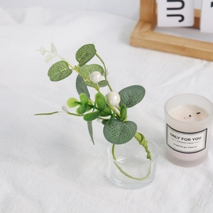 Détail du rond de serviette eucalyptus avec perles sur nappe en lin blanc