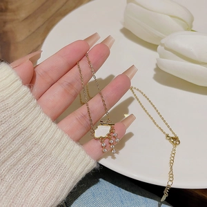 Detail of gold cloud pendant with white inlay and sparkling crystal raindrops on a thin chain