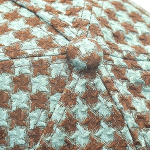 Macro shot of houndstooth pattern fabric and center button on vintage baseball cap