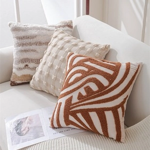 Detailed close-up of textured tufted throw pillows on sofa with geometric embroidery