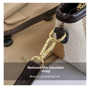 Detail of high-quality gold metal hook and brown leather strap on striped canvas bag