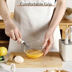 Manual stainless steel egg whisk with ergonomic white handle for kitchen baking and mixing
