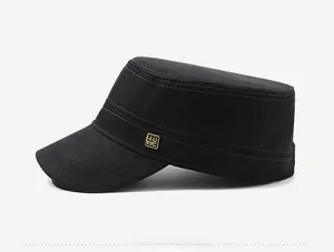 Side view of black flat top military cap with gold metal logo and reinforced stitching