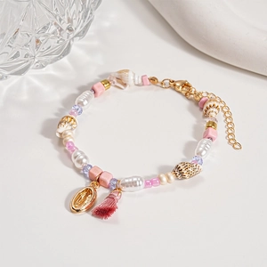 Detail of seashell bracelet with baroque pearls, beads, tassel and Virgin Mary medal