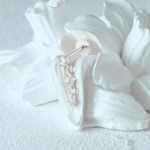 Close-up of S925 sterling silver earring with moonstones on white floral stand