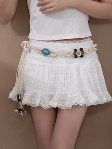 Détail d'une ceinture bohème tressée avec pierres de turquoise et perles sur jupe