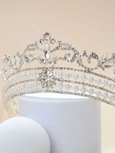 Detail of silver alloy bridal crown with clear rhinestones and triple-layered white pearls