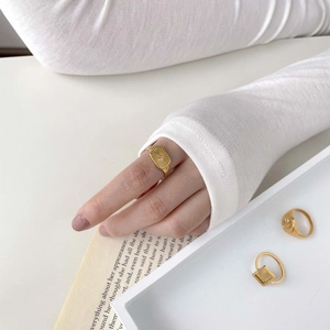 Close-up of a gold oval ring with sunburst engraving and a single sparkling diamond