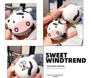 Detail showing eco-friendly PVC cow keychain with golden hook and printed back logo