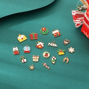 Flat lay of colorful Christmas charms including snowmen and trees on a green background