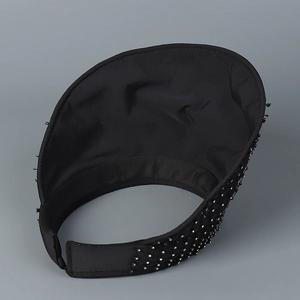 Detail of black rhinestone sun visor hat with sparkling crystals on brim and mesh fabric