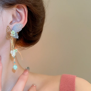 Detailed view of long butterfly tassel earrings with pearls and green flower beads