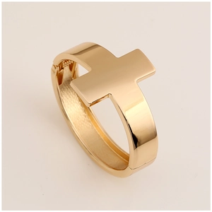 Detail view of the gold-colored cross-shaped bracelet with polished finish and hinge design