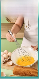 Macro view of stainless steel whisk mixing egg yolks in a bowl for baking