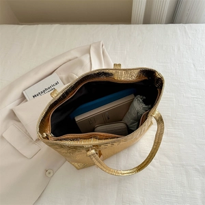 Golden crocodile embossed large tote bag shown from above with interior essentials