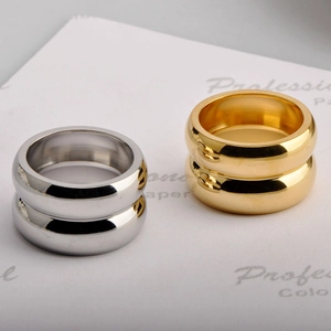 Macro shot of minimalist 18K gold and silver chunky stainless steel rings on paper