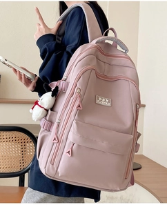 Detail showing the side view of a mauve pink large capacity backpack on a model