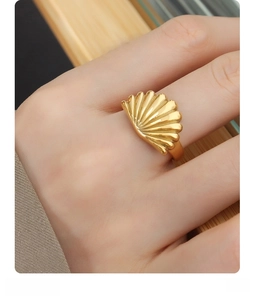 Macro shot of gold plated scallop shell ring showing detailed metal texture and design