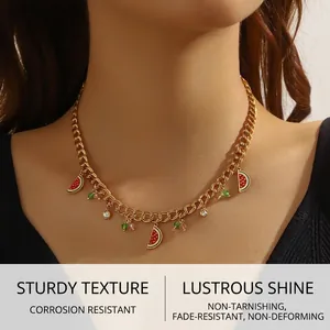 Detail of gold chain necklace featuring enamel watermelon slices and beaded accents