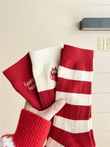 Close-up of red cashmere blend socks featuring cute cat embroidery and striped patterns