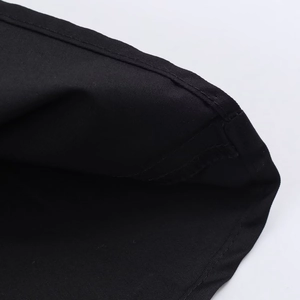 Gros plan sur les coutures et la texture du tissu tissé noir de cette jupe midi chic