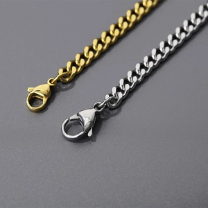 Detail of silver and gold Cuban link chains with lobster clasp on a textured background