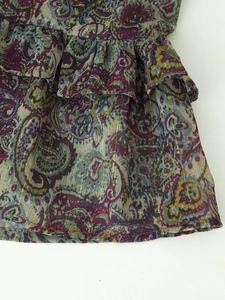 Close-up of ruffled hem with metallic paisley print on this mini dress fabric