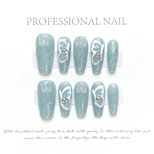 Detailed view of handmade press-on nails with blue glitter and 3D butterfly charms