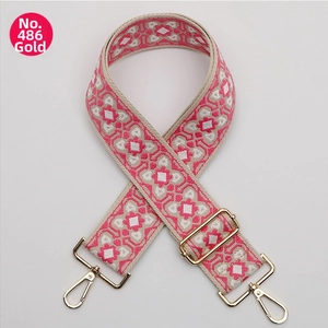 Detail of pink ethnic geometric woven wide bag strap with gold adjustable metal hardware
