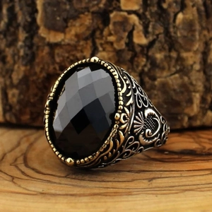 Adjustable men's vintage copper ring with black gemstone and gold accents on wood