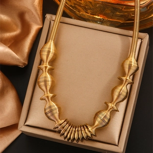 Detailed view of golden spiral spring necklace on a jewelry box with silk background