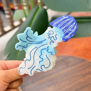 Detail of blue jellyfish hair claw clip made of acetate with star pattern