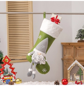 Green felt Christmas stocking with grey faceless gnome and snowflake patterns