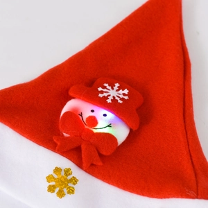 Close-up of a red felt Christmas hat featuring a glowing snowman and golden snowflake motifs