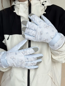 Detail of light blue ski gloves with bunny print, adjustable straps and anti-slip tips