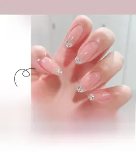 Detail of pink gradient press-on nails with sparkling rhinestones and silver glitter