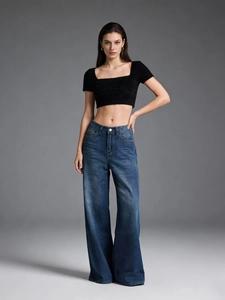 Close-up of high-waist wide-leg denim jeans paired with a black knit crop top