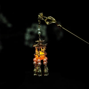 Close-up of golden vintage hair stick with glowing lantern pendant and pearl tassels