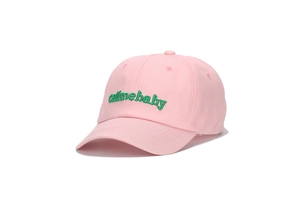 Dettaglio del ricamo callmebaby verde su un cappellino da baseball in cotone rosa