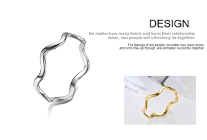 Detail of minimalist wave-shaped titanium steel ring in polished silver and gold finish