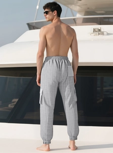 Détail du pantalon cargo gris à carreaux avec poches latérales et ourlet à cordon