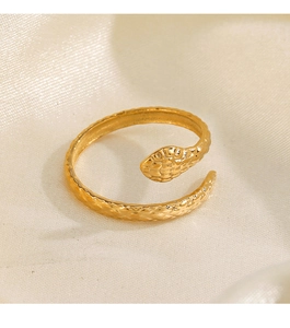 Detailed close-up of golden snake-shaped open ring with intricate scales on beige silk