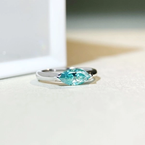 925 sterling silver ring with marquise cut teal moissanite stone on neutral background