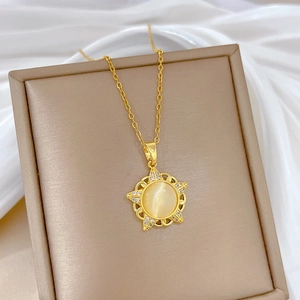 Detail of gold starburst pendant with cat eye stone on a brown leather display stand