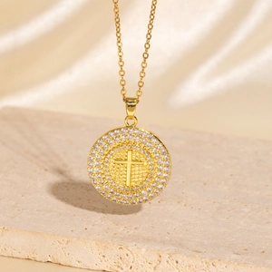 Gold plated cross necklace with zircon stones on a decorative stone base