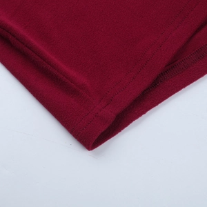 Close-up of red knitted fabric texture and high-quality stitching on the dress hem